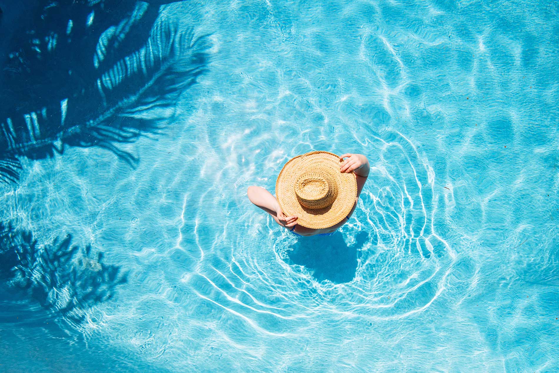 person-walking-in-a-swimming-pool-with-a-hat-on person-walking-in-a-swimming-pool-with-a-hat-on